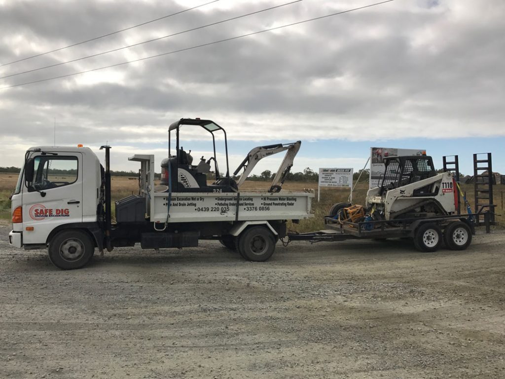 bobcat, excavator, and tipper on site